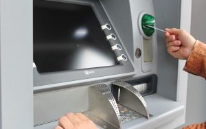 atm with hand using card slot