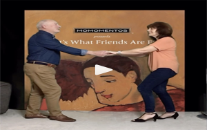 a man and lady stand in front of a picture backdrop holding hands in the middle of a dance, a play button is on this picture as it is taken from a video