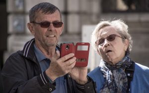 elderly couple looking at mobile phone