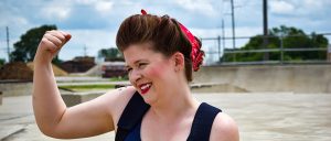 woman smiling outside showing arm muscle