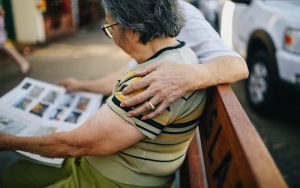 elderly chinese man and woman sitting on a bench outside