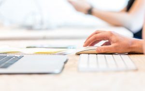 close up of hand clicking a mouse at a desk